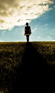 Preview wallpaper girl, field, walking, grass, dark