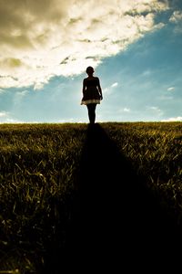 Preview wallpaper girl, field, walking, grass, dark