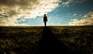 Preview wallpaper girl, field, walking, grass, dark