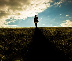 Preview wallpaper girl, field, walking, grass, dark