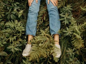 Preview wallpaper girl, legs, jeans, hands, grass