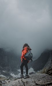 Preview wallpaper girl, loneliness, alone, travel, backpack, fog, rocks