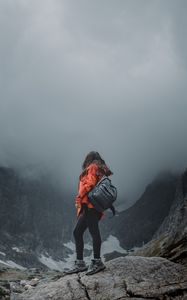 Preview wallpaper girl, loneliness, alone, travel, backpack, fog, rocks