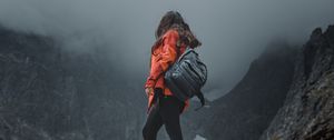 Preview wallpaper girl, loneliness, alone, travel, backpack, fog, rocks