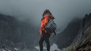 Preview wallpaper girl, loneliness, alone, travel, backpack, fog, rocks