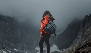 Preview wallpaper girl, loneliness, alone, travel, backpack, fog, rocks