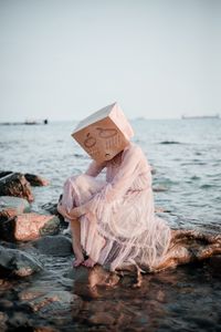 Preview wallpaper girl, mask, sadness, sea, stones