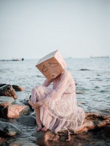 Preview wallpaper girl, mask, sadness, sea, stones