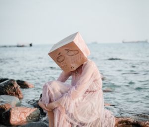 Preview wallpaper girl, mask, sadness, sea, stones