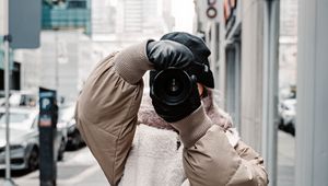 Preview wallpaper girl, photographer, camera, city, buildings