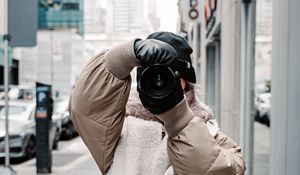 Preview wallpaper girl, photographer, camera, city, buildings