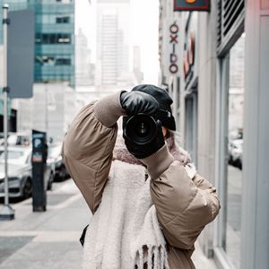 Preview wallpaper girl, photographer, camera, city, buildings