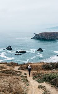 Preview wallpaper girl, sea, walk, travel, rocks, stones, shore