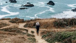 Preview wallpaper girl, sea, walk, travel, rocks, stones, shore