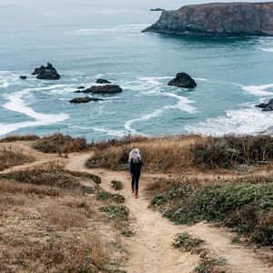 Preview wallpaper girl, sea, walk, travel, rocks, stones, shore