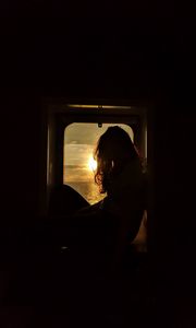 Preview wallpaper girl, silhouette, window, sunset, sun, light, dark