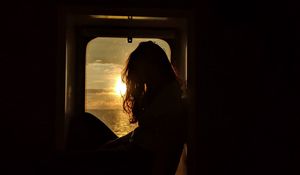 Preview wallpaper girl, silhouette, window, sunset, sun, light, dark