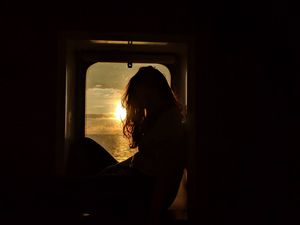 Preview wallpaper girl, silhouette, window, sunset, sun, light, dark