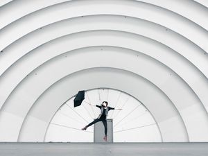 Preview wallpaper girl, umbrella, building, minimalism, jump