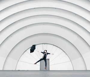 Preview wallpaper girl, umbrella, building, minimalism, jump