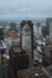 Preview wallpaper glass, drops, city, buildings, wet, macro