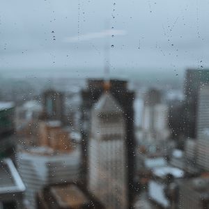 Preview wallpaper glass, drops, city, buildings, wet, macro