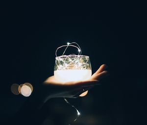 Preview wallpaper glass, garland, hand, light, dark, darkness