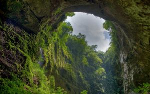 Preview wallpaper gorge, arch, rock, vegetation, green, sky, clouds, from below
