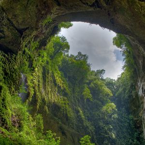 Preview wallpaper gorge, arch, rock, vegetation, green, sky, clouds, from below