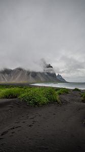 Preview wallpaper grass, coast, sea, mountains, clouds