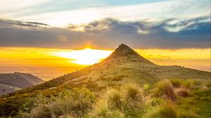 Preview wallpaper grass, mountain, slope, sunset