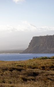 Preview wallpaper grass, sea, slope, mountain, nature, clouds