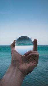 Preview wallpaper hand, ball, glass, reflection, distortion, sea