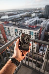 Preview wallpaper hand, camera, city, buildings, roofs