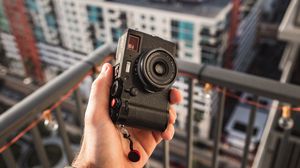 Preview wallpaper hand, camera, city, buildings, roofs