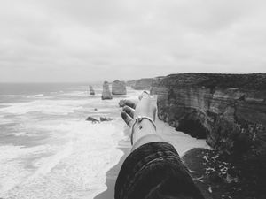 Preview wallpaper hand, coast, bw, cliffs, sea