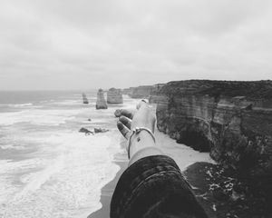 Preview wallpaper hand, coast, bw, cliffs, sea