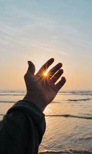 Preview wallpaper hand, fingers, sun, rays, sea, waves