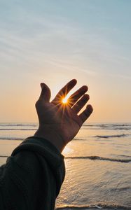 Preview wallpaper hand, fingers, sun, rays, sea, waves