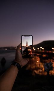 Preview wallpaper hand, phone, photo, bridge, sunset, lights
