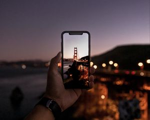 Preview wallpaper hand, phone, photo, bridge, sunset, lights