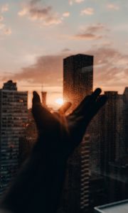 Preview wallpaper hand, rays, sun, city, sunset