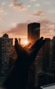 Preview wallpaper hand, rays, sun, city, sunset