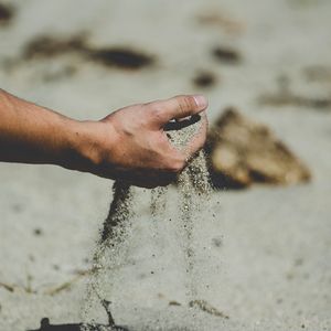 Preview wallpaper hand, sand, pour, beach