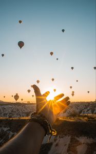 Preview wallpaper hand, sun, air balloons, mountains, sunrise