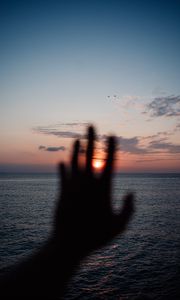 Preview wallpaper hand, sunset, horizon, sea, sky