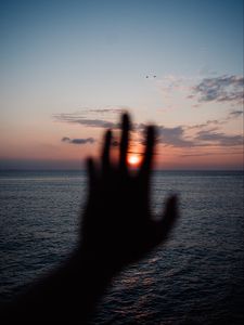 Preview wallpaper hand, sunset, horizon, sea, sky