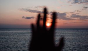 Preview wallpaper hand, sunset, horizon, sea, sky