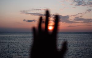 Preview wallpaper hand, sunset, horizon, sea, sky