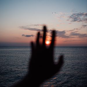 Preview wallpaper hand, sunset, horizon, sea, sky